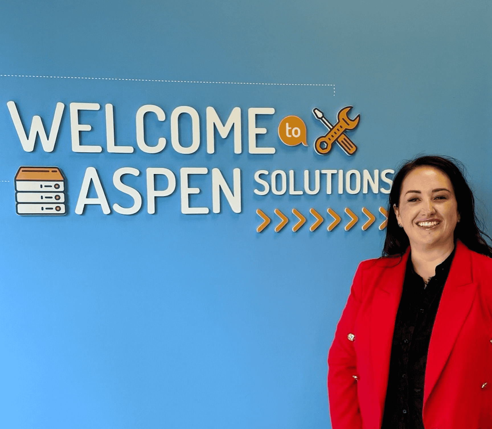 IT Support Glasgow with Mhairi of Aspen Solutions standing next to signage