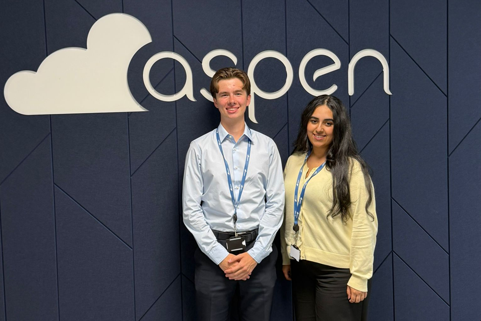 aspen solutions interns standing in front of aspen branding